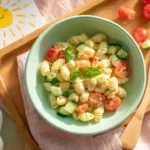 Gluten free pasta salad for kids with cherry tomatoes and cucumbers in pastel tray
