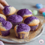 A tray of freshly baked purple sweet potato recipe muffins cooling on a wire rack, styled for family snacking